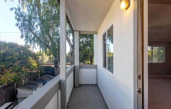 the front porch of a home with a large window and a bench