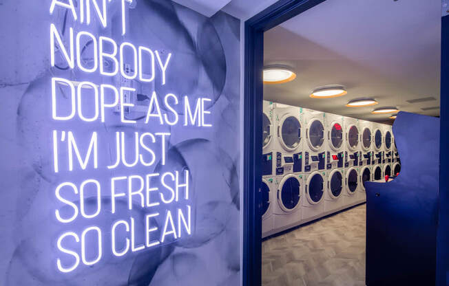 A laundromat with a sign that says "Ain't nobody dope as me I'm just so fresh so clean."