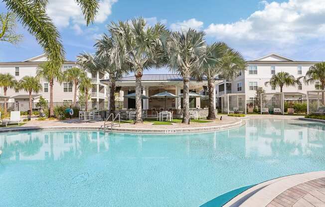 a large swimming pool with palm trees in front of a building at Drift, Daytona Beach, FL, 32117