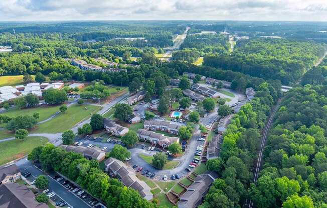 A bird's eye view of a residential area with houses, roads, and greenery.