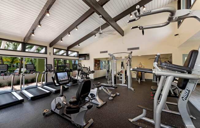 a gym with weights and cardio equipment and windows