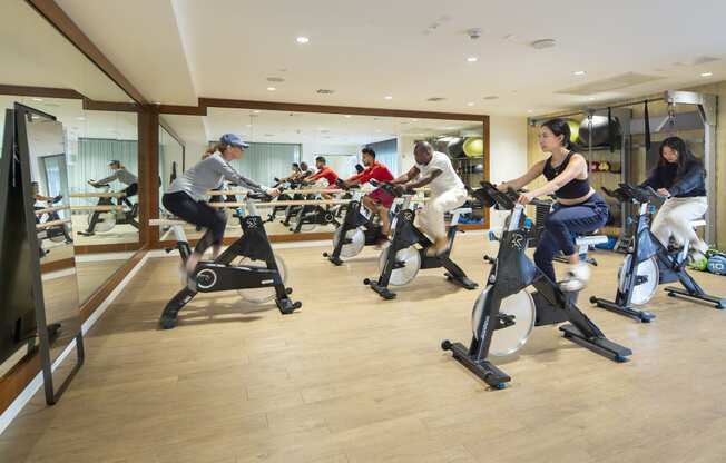 a group of people riding exercise bikes in a gym