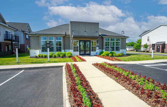 A building with a grey roof and a parking lot in front of it.