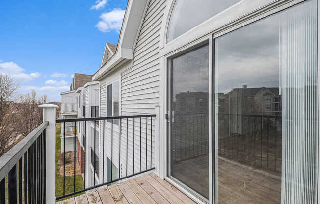 A balcony with enclosed storage and sliding glass doors at Brentwood Park Apartments in LaVista, NE
