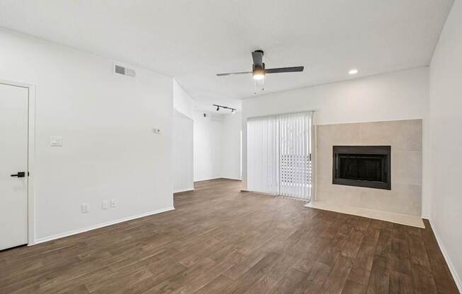 A room with a fireplace and a ceiling fan.