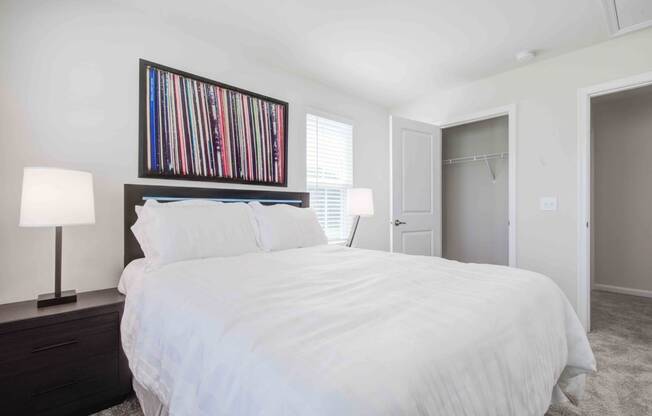 a bedroom with a white bed and a closet