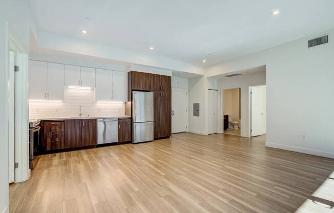 a large living room with a kitchen and a wooden floor