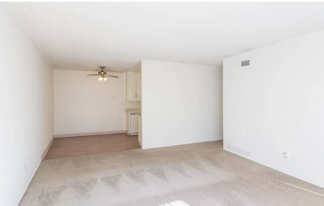 a bedroom with white walls and a ceiling fan