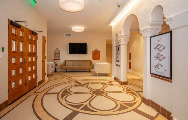 A hallway with a patterned floor and a green exit sign above the door.