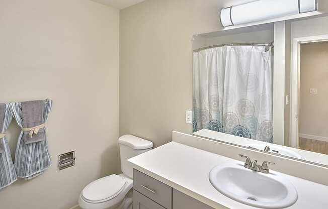 a bathroom with a toilet sink and mirror  at 3030 Lake City, Seattle, 98125