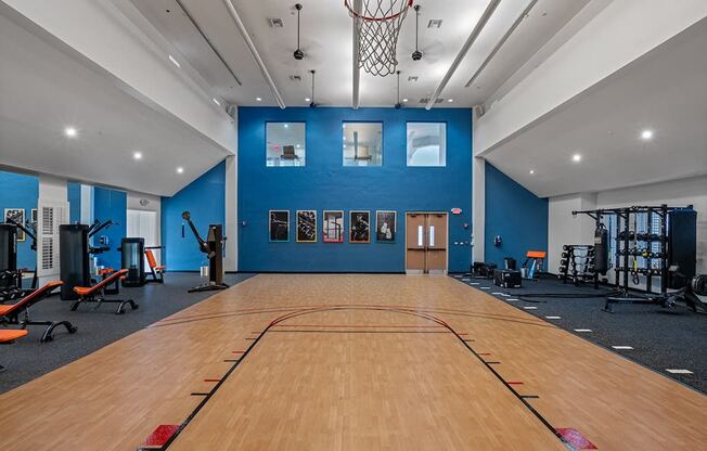 a basketball court in a gym with a basketball hoop and gym equipment