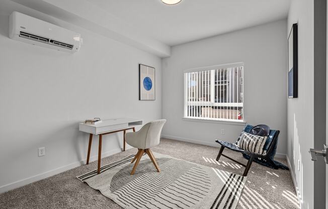 an office space with a desk and a chair and a window