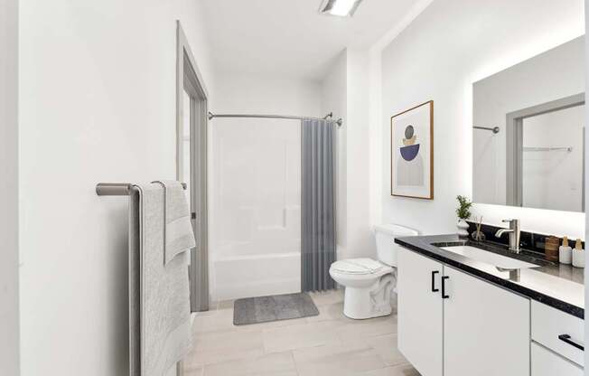 A bathroom with a toilet, sink, and shower.