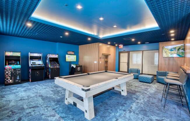 a game room with a pool table and arcade machines at One Ten Apartments, Jersey City , NJ