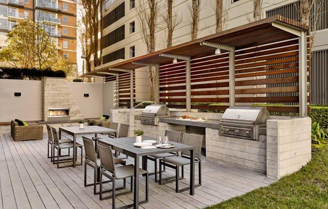 A patio with a table and chairs and a grill.