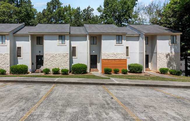 A parking lot in front of a building with four houses.