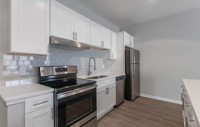 an empty kitchen with white cabinets and stainless steel appliances