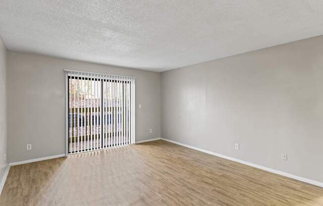 A room with a sliding door and wooden flooring.