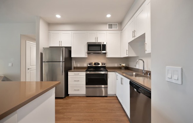 A kitchen with white cabinets and stainless steel appliances.