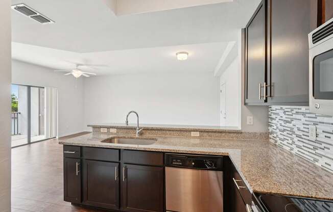 A modern kitchen with a stainless steel dishwasher and black cabinets.