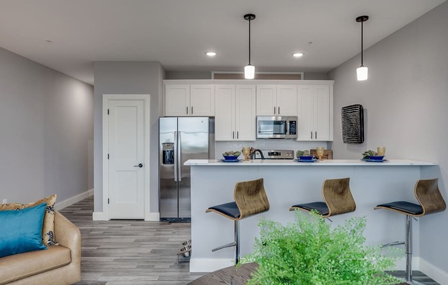 a kitchen and living room with white cabinets and a counter