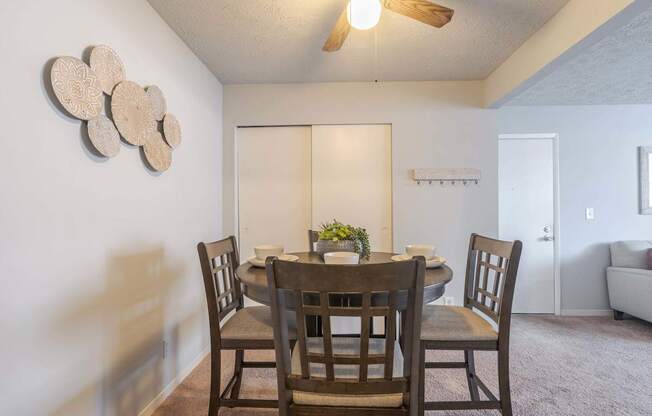 A dining room with a table and chairs.