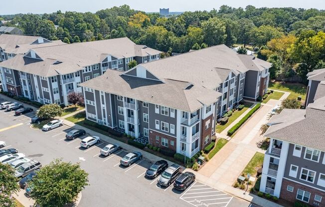 an aerial view of an apartment complex with cars parked in a parking lot