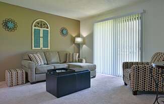 a living room with a couch chairs and a coffee table at Beacon Hill and Great Oaks Apartments, Rockford, Illinois