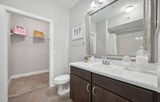 A bathroom with a white toilet, a sink, and a mirror.