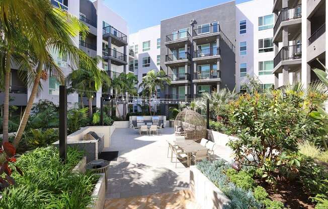 A courtyard surrounded by buildings with a white fence and plants.