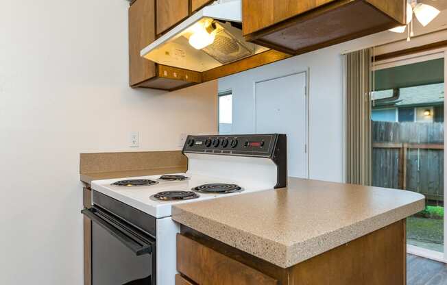 Pinewood Terrace Apartments | Kitchen view looking into dining room showing the patio doors.