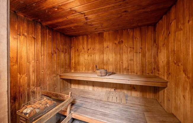 A wooden sauna with a bench and a table.
