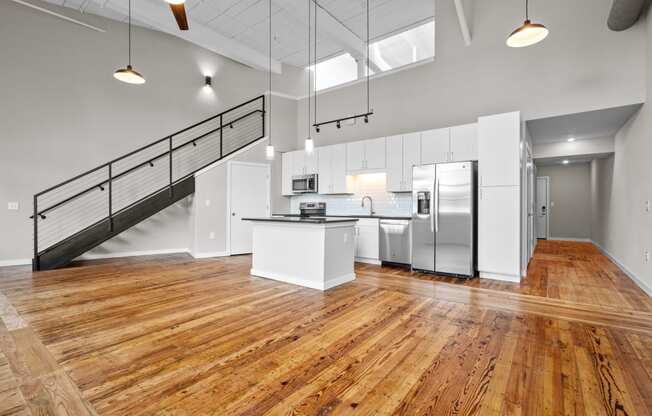 an open kitchen with stainless steel appliances and white cabinets at Spinning Mill Lofts, Clayton, NC 27520