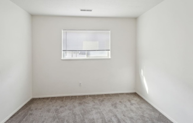 an empty room with white walls and a window