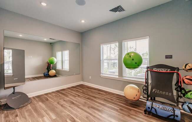 a workout room with a treadmill and weights and a window