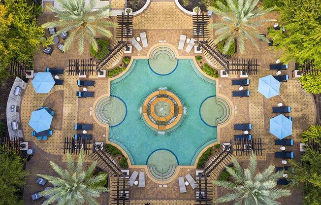 a birds eye view of a pool with tables and umbrellas