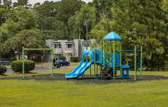 A playground with a blue slide and a green structure.