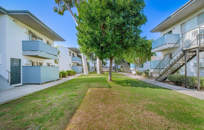 a grassy area between two buildings with trees in the middle at BLVD Apartments LLC, Tarzana, 91356