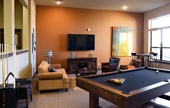 a living room with a pool table and a television