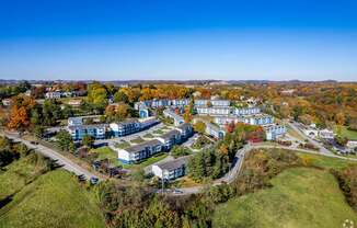 An aerial view of a large building complex surrounded by trees in autumn colors.