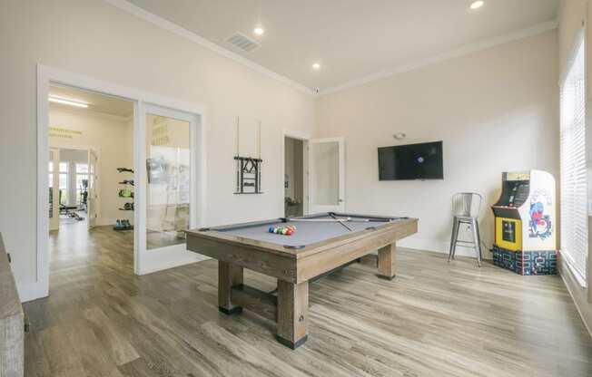 a games room with a pool table and a television