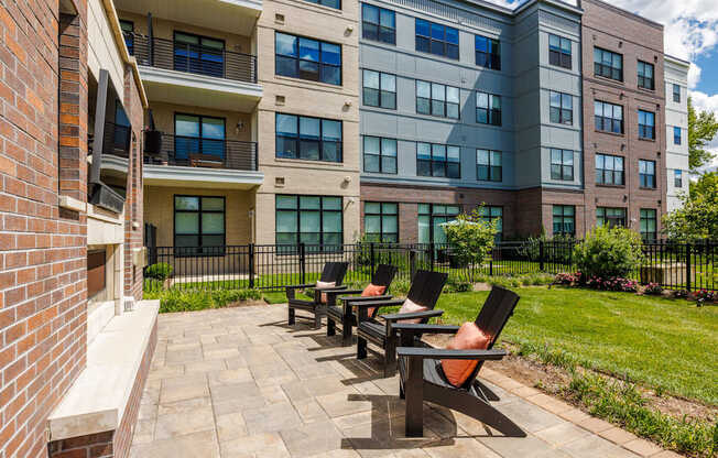 A row of black chairs are lined up on a patio.