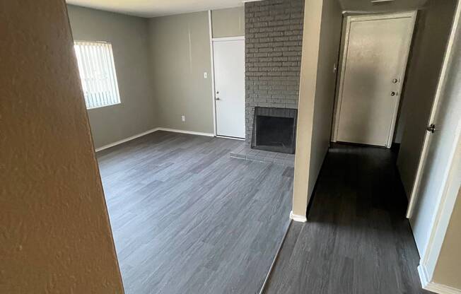 Upgraded living room and entry with luxury vinyl plank flooring, gray finishes and cozy fireplace