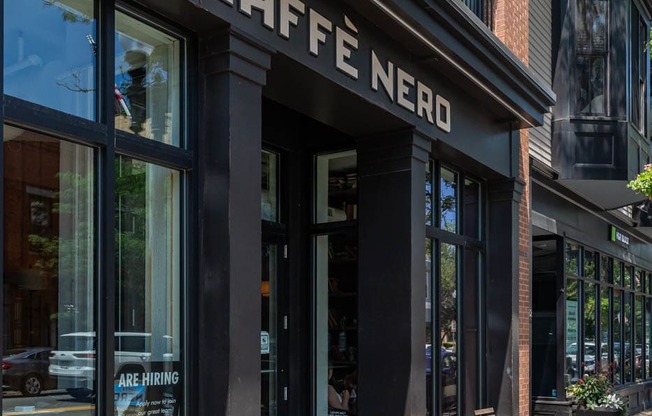 a coffee shop on the corner of a city street "Cafe nero"