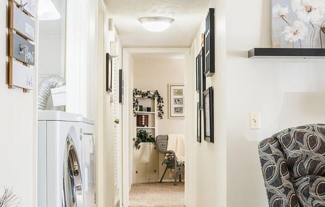 a laundry room with a washer and dryer and a dining room in the background