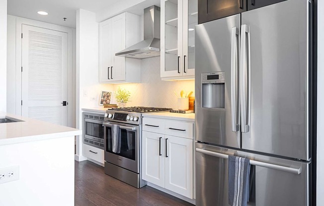 A modern kitchen with stainless steel appliances and white cabinets.