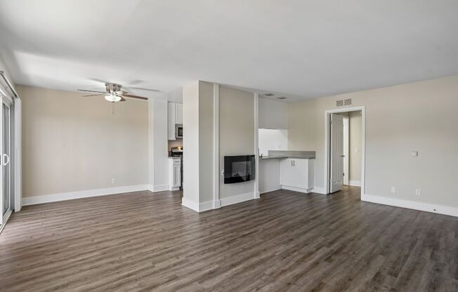 A living room with a television and a wood floor.
