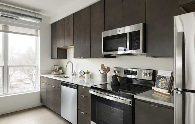 a kitchen with dark wood cabinets and stainless steel appliances