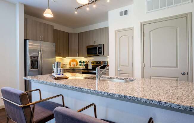 A kitchen with a granite countertop and a refrigerator.
