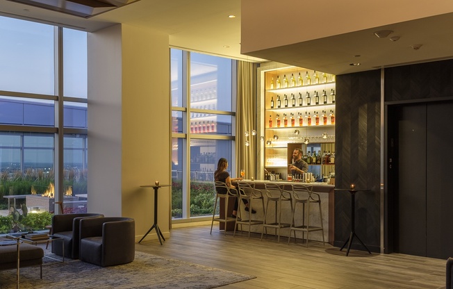 A woman is sitting at a bar in a modern room.